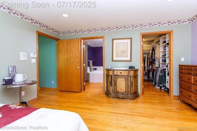 8808 Big Lake Rd, Clarkston, MI 48346 - bedroom featuring a spacious closet, light wood-type flooring, recessed lighting, and ensuite bathroom