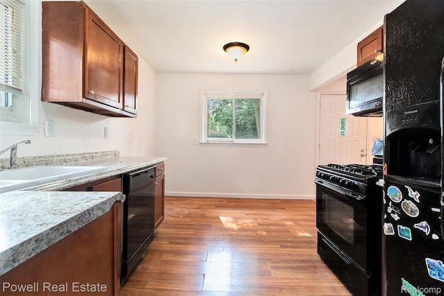 7642 Arcola Ave, Westland, MI 48185 - kitchen featuring black appliances, hardwood / wood-style floors, and light countertops
