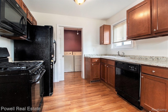 7642 Arcola Ave, Westland, MI 48185 - kitchen featuring black appliances, washing machine and clothes dryer, light wood finished floors, and brown cabinets