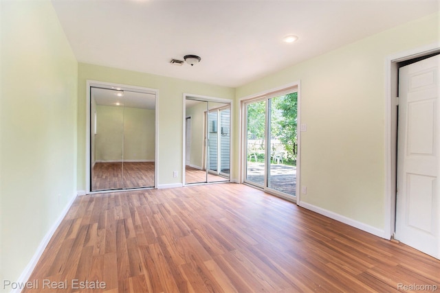 7642 Arcola Ave, Westland, MI 48185 - unfurnished bedroom featuring access to outside, wood finished floors, and two closets
