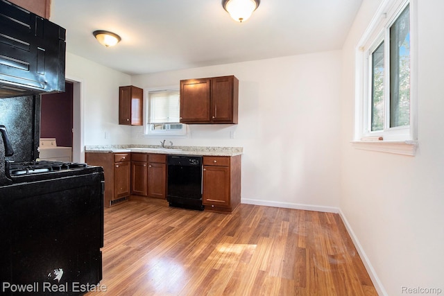7642 Arcola Ave, Westland, MI 48185 - kitchen featuring black appliances, light wood-style flooring, and light countertops
