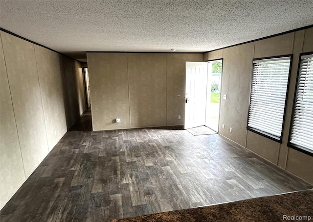 8499 LOT214 E M 71, Durand, MI 48429 - spare room with wood finished floors, a textured ceiling, and a decorative wall