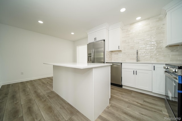 45293 Heatherwoode Ln, Macomb, MI 48044 - kitchen with appliances with stainless steel finishes, light countertops, white cabinets, decorative backsplash, and a kitchen island