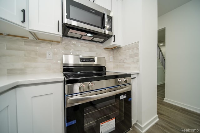 45293 Heatherwoode Ln, Macomb, MI 48044 - kitchen featuring appliances with stainless steel finishes, light countertops, dark wood-style floors, white cabinets, and tasteful backsplash