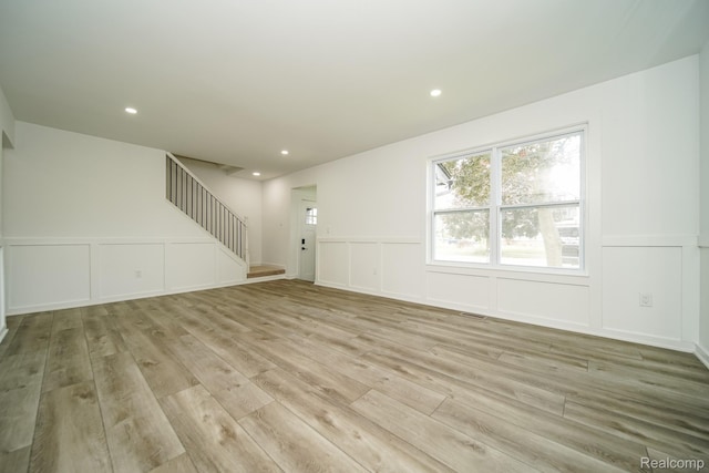 45293 Heatherwoode Ln, Macomb, MI 48044 - unfurnished living room featuring a decorative wall, light wood finished floors, stairway, recessed lighting, and a wainscoted wall