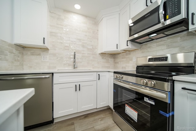 45293 Heatherwoode Ln, Macomb, MI 48044 - kitchen with stainless steel appliances, light countertops, light wood-style floors, white cabinetry, and recessed lighting