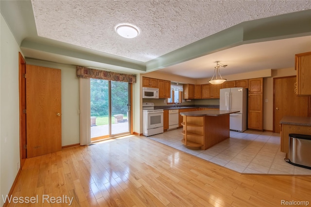 2465 Texter Rd, Leonard, MI 48367 - kitchen with dark countertops, white appliances, a textured ceiling, a kitchen island, and brown cabinetry