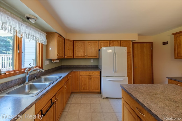 2465 Texter Rd, Leonard, MI 48367 - kitchen with freestanding refrigerator, brown cabinets, dark countertops, and light tile patterned floors