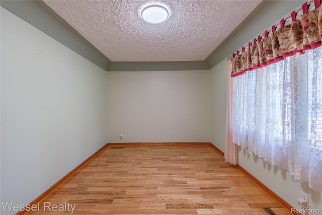 2465 Texter Rd, Leonard, MI 48367 - empty room with a textured ceiling and light wood-style floors