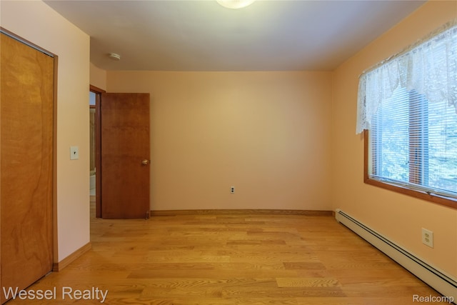 2465 Texter Rd, Leonard, MI 48367 - empty room with baseboard heating and light wood-style flooring