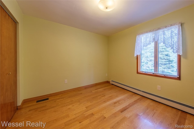 2465 Texter Rd, Leonard, MI 48367 - unfurnished room with a baseboard radiator and light wood-type flooring