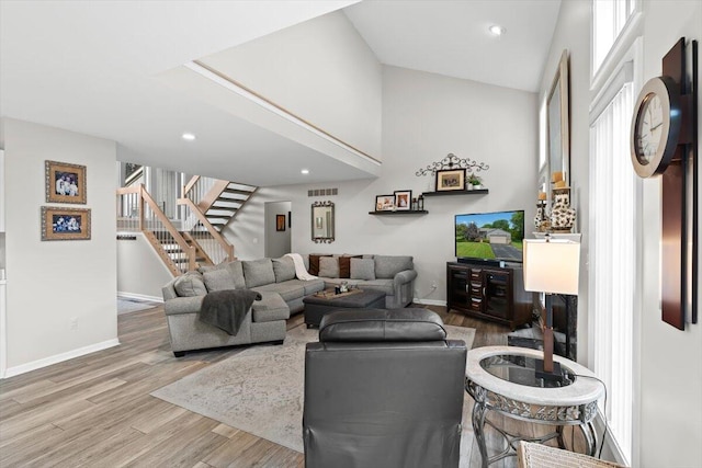 1683 Majon Dr, Highland, MI 48356 - living room with stairway, wood finished floors, a towering ceiling, plenty of natural light, and recessed lighting
