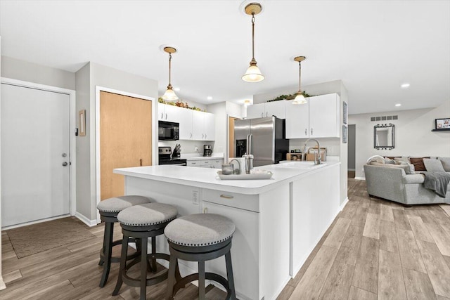 1683 Majon Dr, Highland, MI 48356 - kitchen with stainless steel appliances, light wood-style flooring, light countertops, white cabinetry, and recessed lighting