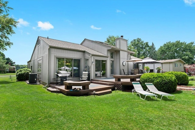 1683 Majon Dr, Highland, MI 48356 - back of property featuring a chimney, a yard, and a wooden deck