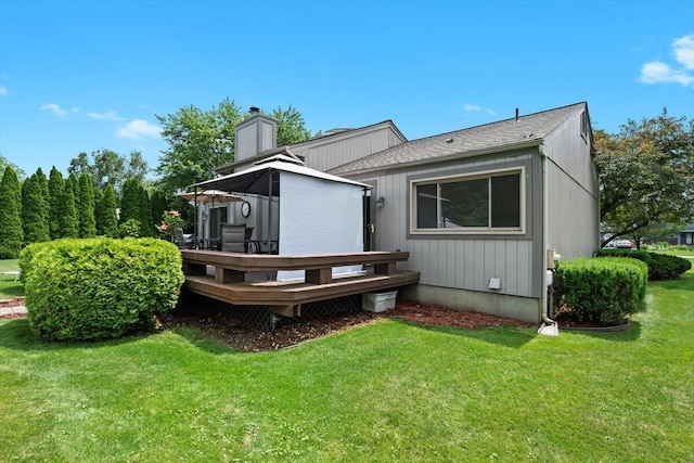 1683 Majon Dr, Highland, MI 48356 - rear view of property featuring a wooden deck, a yard, and a chimney