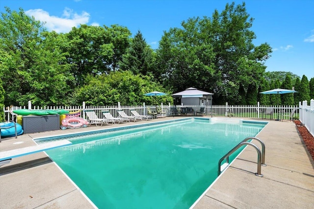 1683 Majon Dr, Highland, MI 48356 - view of swimming pool featuring a patio area, a diving board, and view of scattered trees
