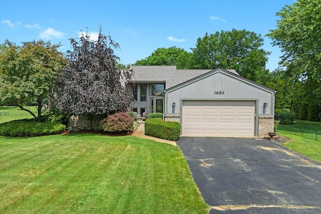 1683 Majon Dr, Highland, MI 48356 - view of front of property featuring asphalt driveway, a front yard, an attached garage, and brick siding