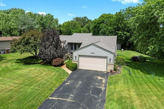 1683 Majon Dr, Highland, MI 48356 - view of front of property with asphalt driveway, an attached garage, a front lawn, brick siding, and roof with shingles