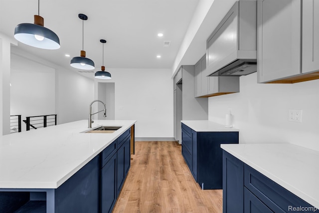 4301 Avery St, Detroit, MI 48208 - kitchen featuring blue cabinets, light wood-type flooring, recessed lighting, and hanging light fixtures