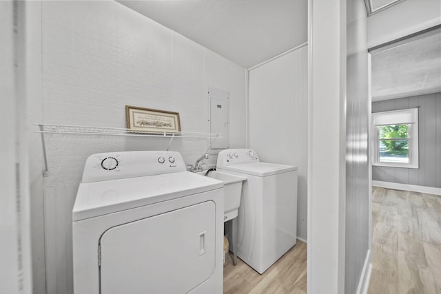 1533 E Munger Rd, Tecumseh, MI 49286 - laundry area featuring light wood-style floors, electric panel, and washing machine and clothes dryer