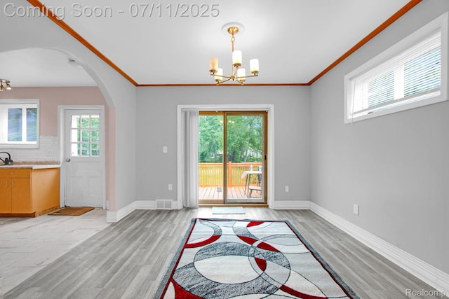 24370 Eureka Ave, Warren, MI 48091 - dining space with arched walkways, a chandelier, light wood-style floors, and ornamental molding