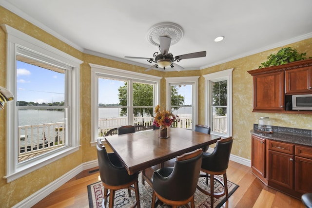 8321 Odowling Dr, Onsted, MI 49265 - dining space featuring light wood-type flooring, ceiling fan, a water view, and crown molding