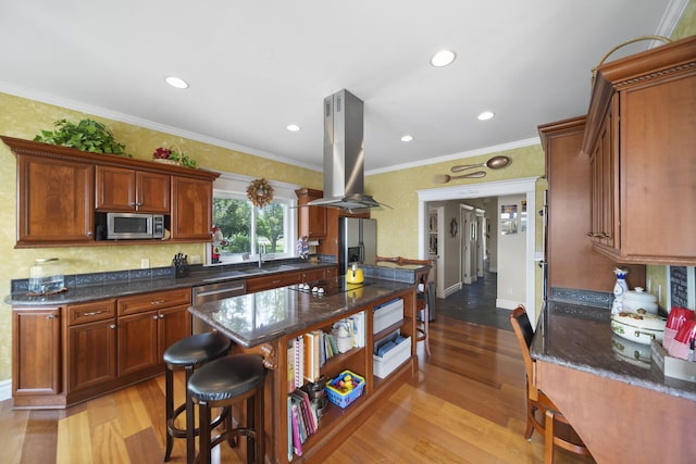 8321 Odowling Dr, Onsted, MI 49265 - kitchen featuring stainless steel appliances, island range hood, light wood-style flooring, crown molding, and a kitchen breakfast bar