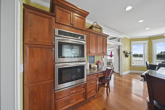 8321 Odowling Dr, Onsted, MI 49265 - kitchen featuring double oven, wood finished floors, ornamental molding, built in study area, and recessed lighting