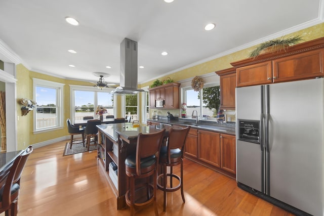 8321 Odowling Dr, Onsted, MI 49265 - kitchen featuring stainless steel appliances, island range hood, dark countertops, a ceiling fan, and light wood-type flooring