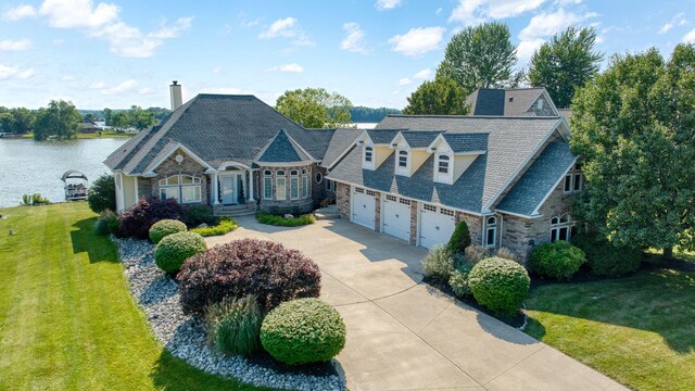 8321 Odowling Dr, Onsted, MI 49265 - view of front facade with stone siding, driveway, a front yard, and a water view