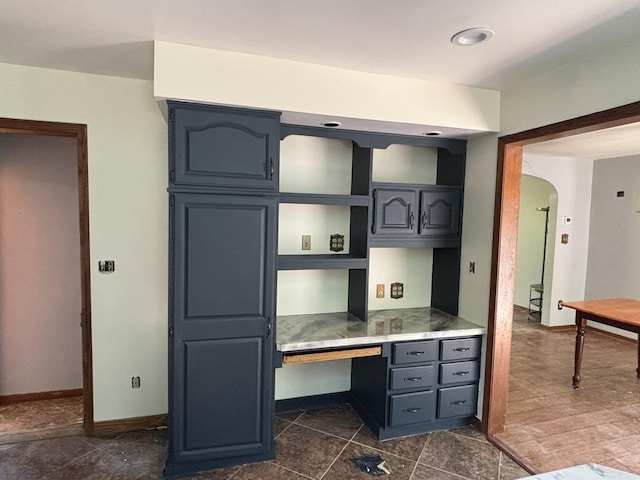 135 S Steer St, Addison, MI 49220 - kitchen featuring arched walkways, built in desk, and light countertops