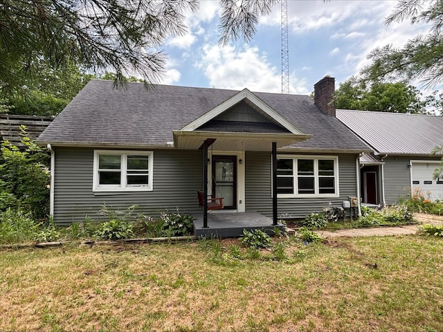 135 S Steer St, Addison, MI 49220 - view of front of property featuring covered porch, a front yard, a chimney, and a shingled roof