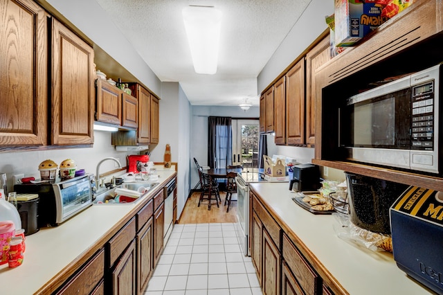 287-289 S Waverly Rd, Holland, MI 49423 - kitchen featuring appliances with stainless steel finishes, light countertops, brown cabinetry, a textured ceiling, and light tile patterned floors