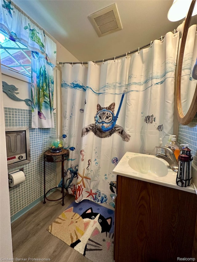 7351 Chain Lake Dr, South Branch, MI 48761 - bathroom featuring vanity, wood finished floors, curtained shower, and tile walls