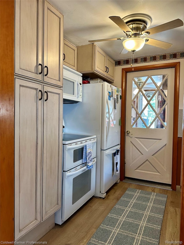 7351 Chain Lake Dr, South Branch, MI 48761 - kitchen with white appliances, ceiling fan, light wood-style flooring, and dark countertops