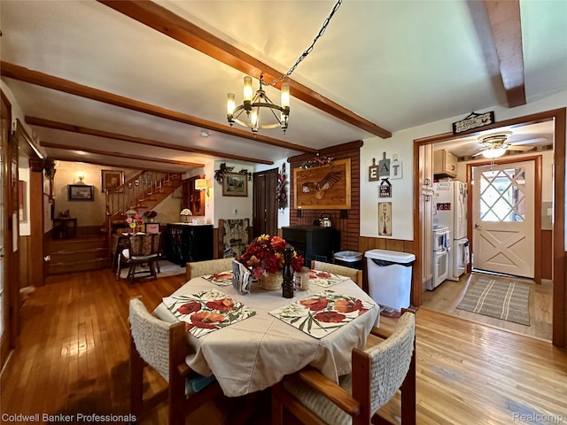 7351 Chain Lake Dr, South Branch, MI 48761 - dining room featuring beamed ceiling, light wood-style flooring, stairs, a chandelier, and wainscoting