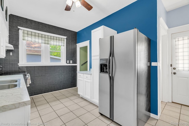 509 13th St, Port Huron, MI 48060 - kitchen featuring stainless steel fridge, light tile patterned floors, a ceiling fan, white cabinets, and light countertops