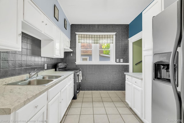 509 13th St, Port Huron, MI 48060 - kitchen featuring appliances with stainless steel finishes, light tile patterned flooring, light countertops, and white cabinetry