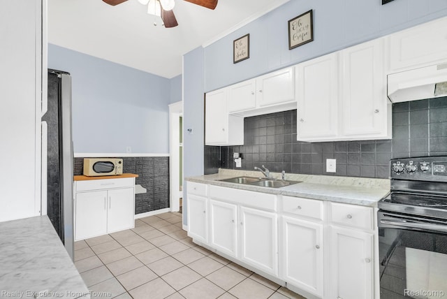 509 13th St, Port Huron, MI 48060 - kitchen featuring black range with electric cooktop, a ceiling fan, white microwave, and white cabinetry