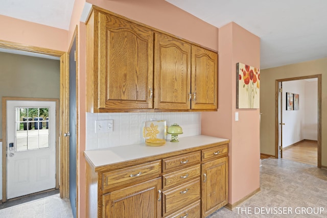 817 Central Ave, Holland, MI 49423 - kitchen featuring light countertops, decorative backsplash, and brown cabinets