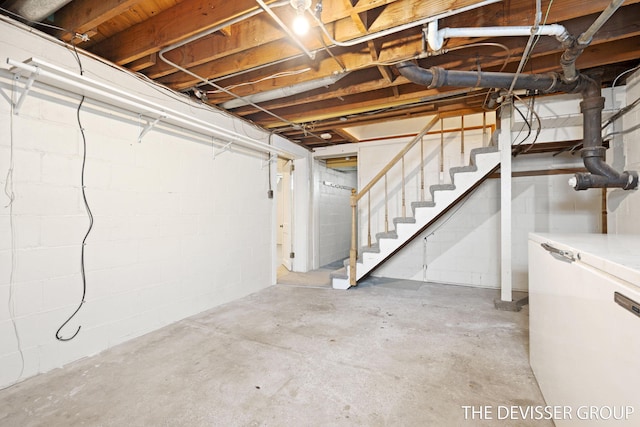 817 Central Ave, Holland, MI 49423 - unfinished basement with stairs, concrete block wall, and refrigerator