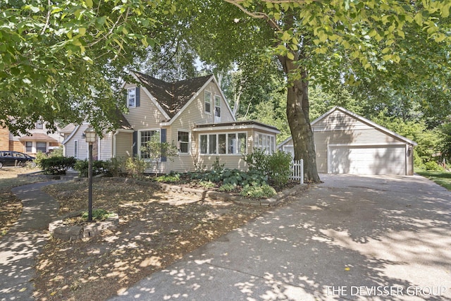 817 Central Ave, Holland, MI 49423 - view of front facade with an outbuilding, concrete driveway, a garage, and a sunroom