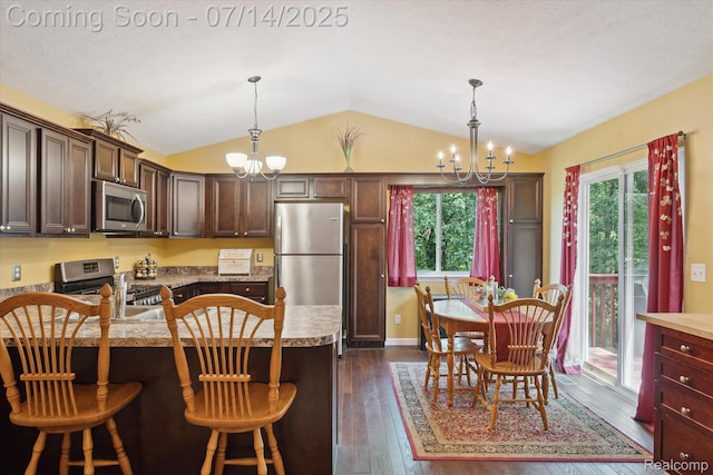9481 Common Trl, Pinckney, MI 48169 - kitchen with appliances with stainless steel finishes, a chandelier, vaulted ceiling, dark wood-style floors, and decorative light fixtures