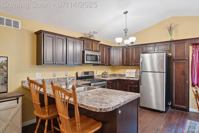 9481 Common Trl, Pinckney, MI 48169 - kitchen featuring stainless steel appliances, a peninsula, dark brown cabinetry, a chandelier, and lofted ceiling