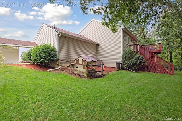 9481 Common Trl, Pinckney, MI 48169 - view of property exterior featuring stairway, a yard, a deck, and an attached garage