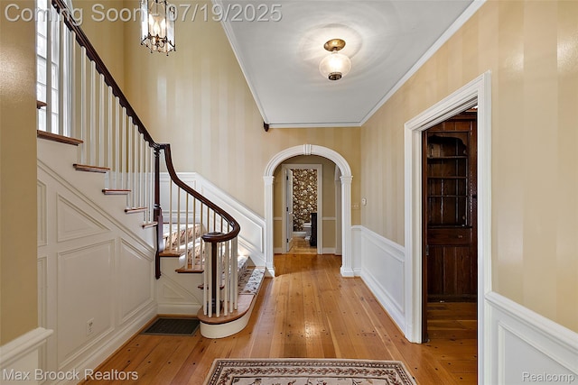 748 Waddington St, Bloomfield Hills, MI 48301 - entryway with arched walkways, light wood finished floors, a decorative wall, ornamental molding, and a wainscoted wall