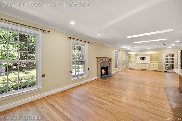 748 Waddington St, Bloomfield Hills, MI 48301 - unfurnished living room with a skylight, ornamental molding, a fireplace with flush hearth, light wood finished floors, and recessed lighting