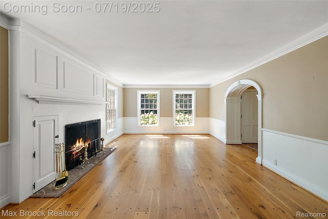 748 Waddington St, Bloomfield Hills, MI 48301 - unfurnished living room featuring a fireplace with flush hearth, light wood finished floors, arched walkways, and crown molding