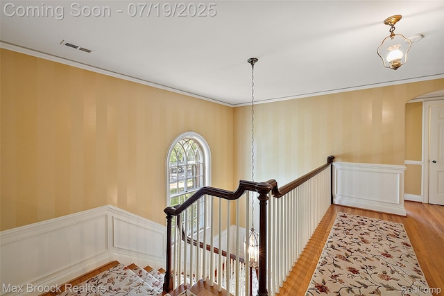 748 Waddington St, Bloomfield Hills, MI 48301 - staircase featuring a wainscoted wall, wood finished floors, ornamental molding, arched walkways, and wallpapered walls