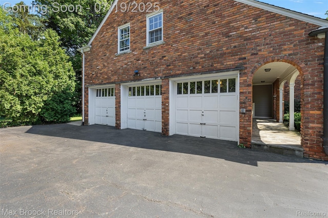 748 Waddington St, Bloomfield Hills, MI 48301 - view of property exterior with an attached garage, brick siding, and asphalt driveway